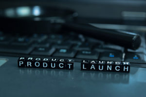 Product Launch text wooden blocks in laptop background. Business and technology concept