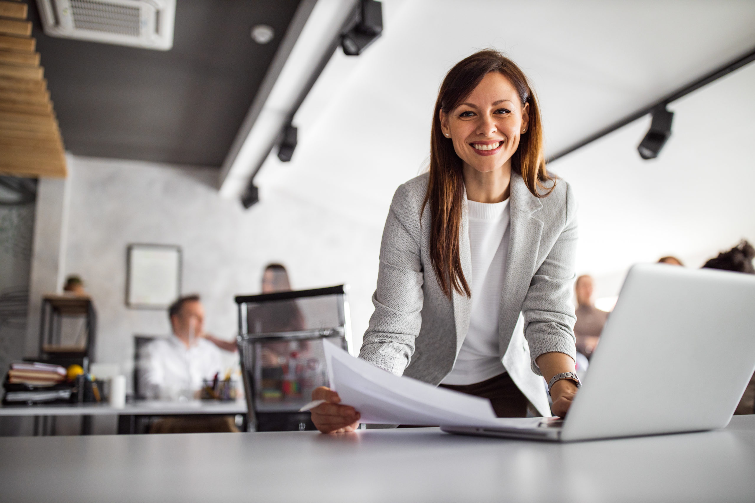 Woman standing in front of a laptop at the office