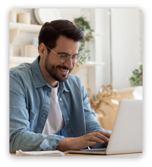 Smiling young man freelancer using laptop studying online working from home, happy casual millennial guy typing on pc notebook surfing internet looking at screen enjoying distant job sit at table